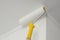 Paint roller with yellow handle. Ceiling and wall painting process. White background.