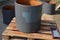 Paint rusty flower pots in the shape of a cylinder. gray color is applied using a brush and a foam roller. ball painter soaked too