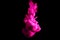 Paint stream in water, colored cloud, abstract background, process of dissolution pink dye on a black background