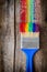 Paintbrush and multicolor rainbow brush strokes on wooden plank