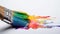Paintbrush with rainbow paint on white background