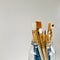 Paintbrushes in a glass jar isolated on grey background. Square.