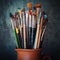 Paintbrushes in a jug on dark panting background