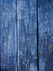Painted blue wood surface, with an abstract expressive vertical line texture. Pastel background for design