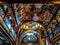 Painted ceiling with large chandeliers and a dome in the El Sama-eyeen Coptic Orthodox