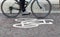 Painted cycle path bicycle sign on the ground with a rider passing.  Motion blurr on the bike