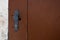 Painted door handle and keyhole of a brown barn door. Copy space