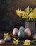 Painted Easter eggs with daffodil flowers on dark rustic background