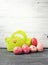 Painted Easter Eggs in decorated green basket on wooden table.