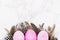 Painted Easter pink eggs with stylish feathers on a marble background. Holiday background.