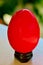 Painted egg red on a small stand on a white table