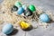 Painted eggs in tray, chicken eggs, paint and brush on concrete surface, Easter decorations