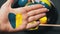 Painted Female Hand in Yellow-Blue Color on the Background of Easter Eggs