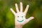 Painted smiley face on the palm against green background