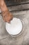 A painter dips his roller into a white paint can. Looking down, top view. Construction or home renovation