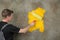 Painter repaints a structured wall in yellow with a color roller