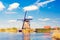 Painting beautiful picture of windmills in Kinderdijk, Netherlands, Europe against the backdrop of a cloudy sky.