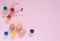 Painting chicken eggs for Easter celebrating. Decorated eggs, colorful paintings and brushes on pink with copyspace