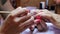 Painting nails.  Manicure master holding beautiful woman ring-finge