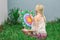 Painting outdoors, a young woman blonde draws a mandala on the nature sitting in the grass