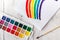 Painting of rainbow on notebook or sketch book with paintbrush on wooden planks for background