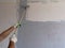 Painting the wall with a roller on a long handle