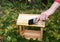 Painting wooden bird feeder for rain protection. Repair bird feeder covering with drying oil. - Image