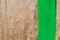 Paints and brush on a wooden background. Part painted wooden surface green color