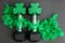 Pair of 15-pound dumbbells on a black gym floor, green feather boa, green shamrocks