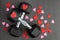 Pair of 15-pound dumbbells on a black gym floor, red and pink sparkly hearts