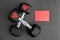 Pair of 15-pound dumbbells on a black gym floor, red sparkly hearts, red note card