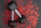 Pair of 15-pound dumbbells on a black gym floor, shiny red confetti hearts