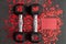 Pair of 15-pound dumbbells on a black gym floor, shiny red confetti hearts, red note card