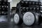 A pair of 30 kilo dumbbells on the floor with a dumbbell rack at the background.