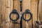 Pair of antique iron door handles on wooden door