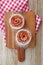 Pair of Apple Rose Shaped Tartlets Sprinkled with Powder Sugar on a Wooden Breadboard