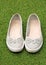 A pair of ballerina style shoes on a green grass background