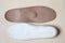 Pair beige orthopedic shoe insoles on cream background