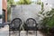 Pair of black cane outdoor chairs in modern courtyard