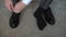 A pair of black shoes on a floor closeup. Unrecognizable man put on boots.