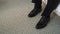 A pair of black shoes on a floor closeup. Unrecognizable man put on boots.