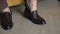 A pair of black shoes on a floor closeup. Unrecognizable man put on boots.
