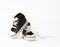 Pair of black textile children`s sneakers with white untied shoelaces