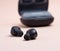 pair of black wireless little earphones and a charging box