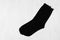 Pair blank black tall socks side view flat lay on white wood board as mock up for design, print, presentation, advertising.