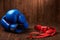 Pair of blue boxing gloves with two rolls of hand bandage on wooden background.