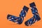 A pair of blue socks, on an orange background, as if walking, concept, comfort