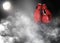 Pair of boxing gloves and white smoke illuminated by spotlight on dark background