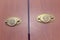 Pair of brass folding pull handles on wooden doors of wardrobe