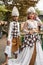 a pair of brides in white clothes standing together very intimately in a tourist park